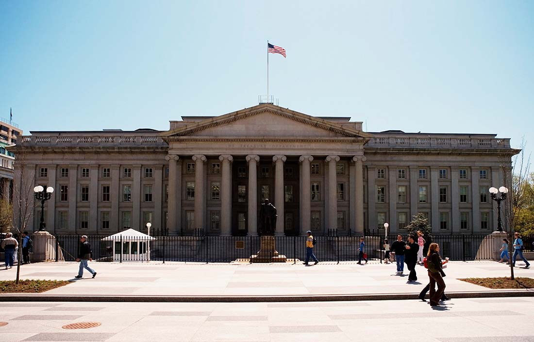 People walking in front of a U.S. government building in daytime.