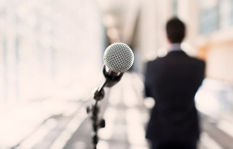 Image of a microphone with a man next to it