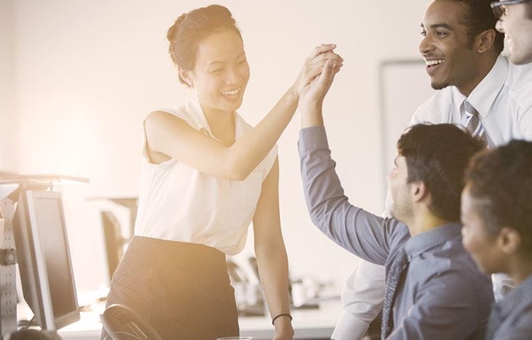 Image of business people giving high fives.