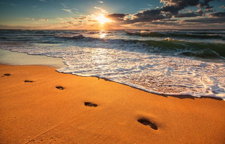 Footsteps on the beach at sunset. 