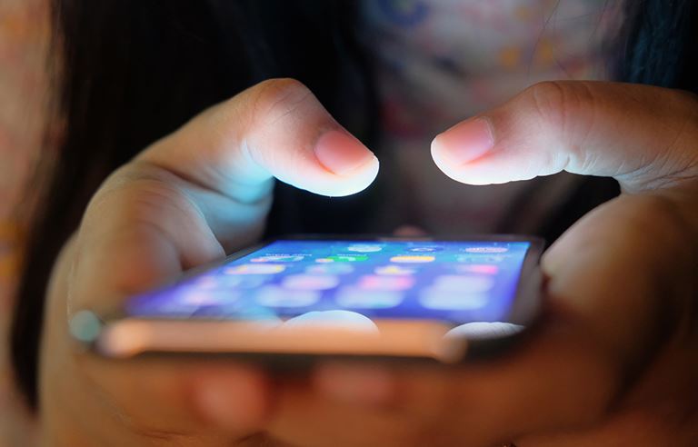 Close up picture of two hands holding an iPhone