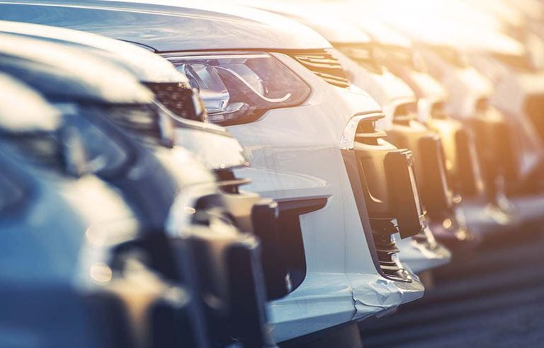 Row of parked cars showing only the front bumper