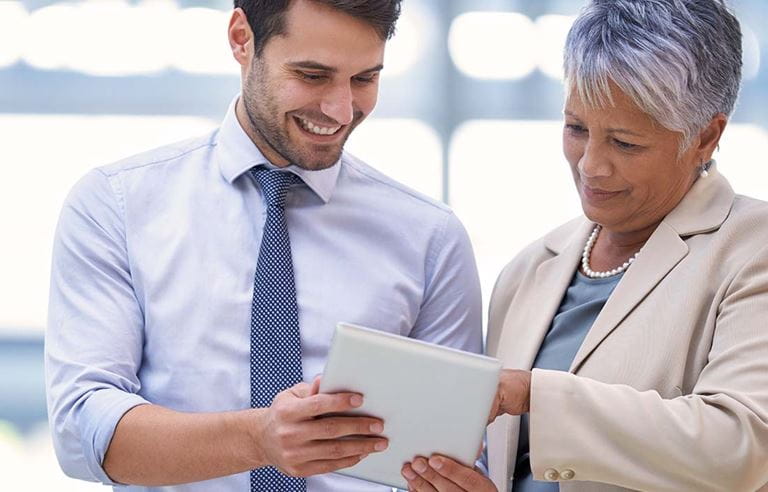 Image of two people looking at tablet