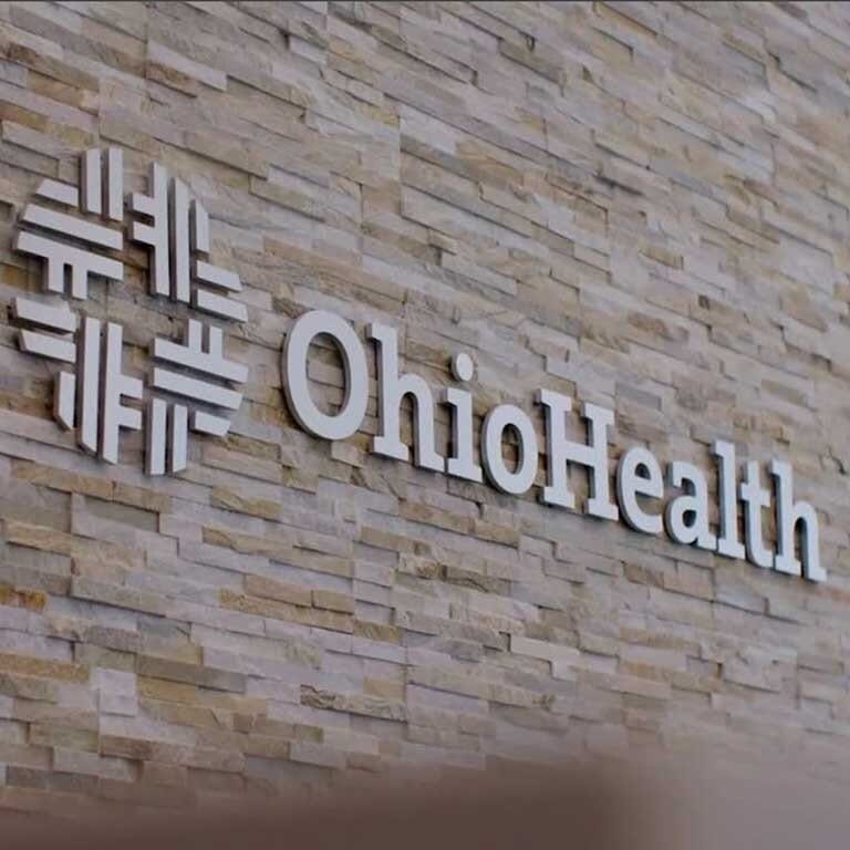 Close-up photo of OhioHealth's sign and logo on the side of a brick wall