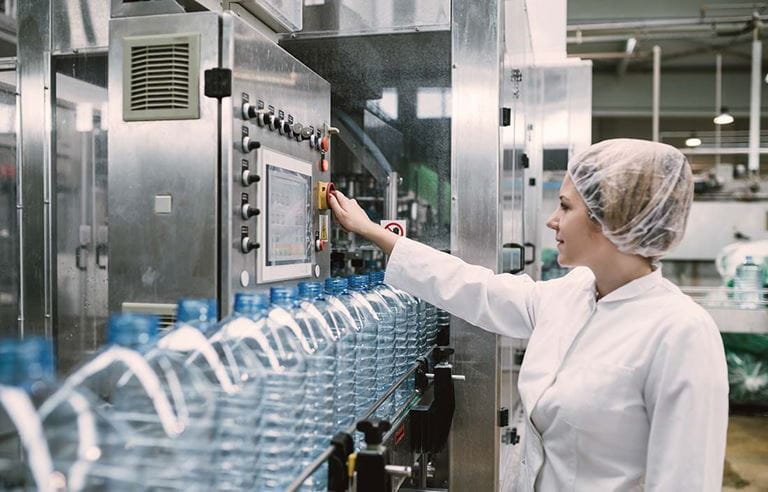 Lady working in a factory using an industrial machine. 