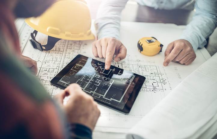 Construction professional reviewing blueprints.