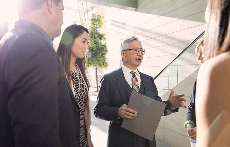 Business colleagues talking in a foyer area near a stairwell. 