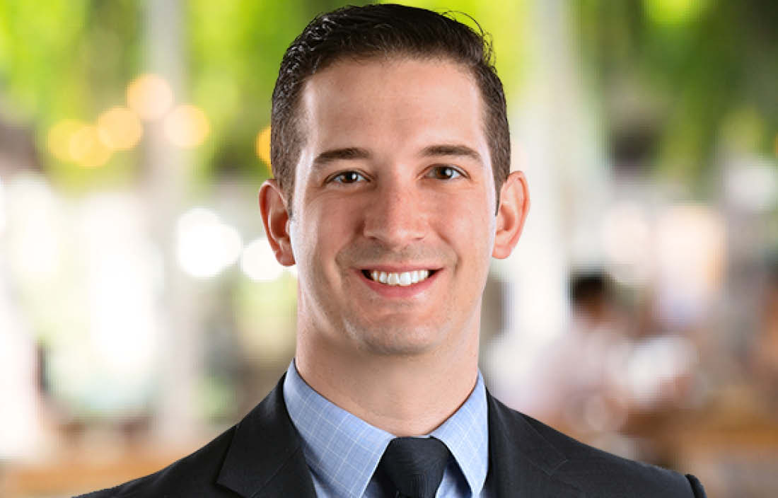 Professional photo of Rob Forte in front of brightly colored, blurred background.