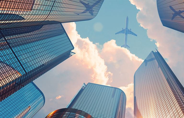 Skyscrapers framing a cottoncandy sky and airplane