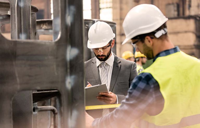 men with hard hats working in a manufacturing setting