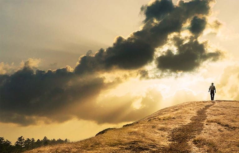 ominous scene of man silhouette of walking toward a sunset