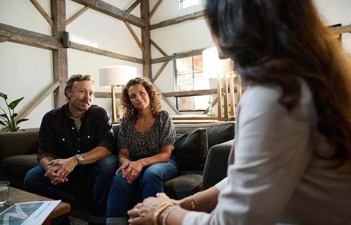 Wealth couple talking with their financial advisor.