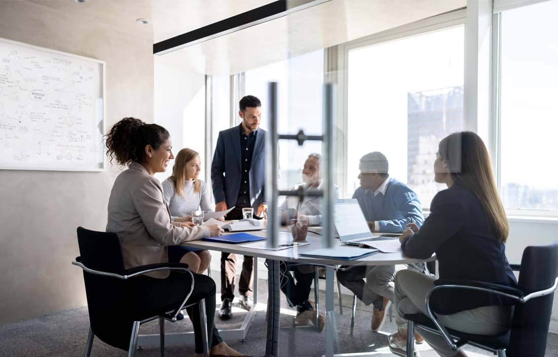 Public sector professionals having a roundtable discussion about the ERP lifecycle using a whiteboard.
