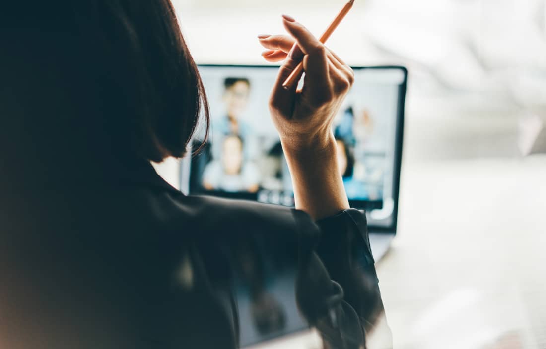 Business professional watching a webinar on their laptop.