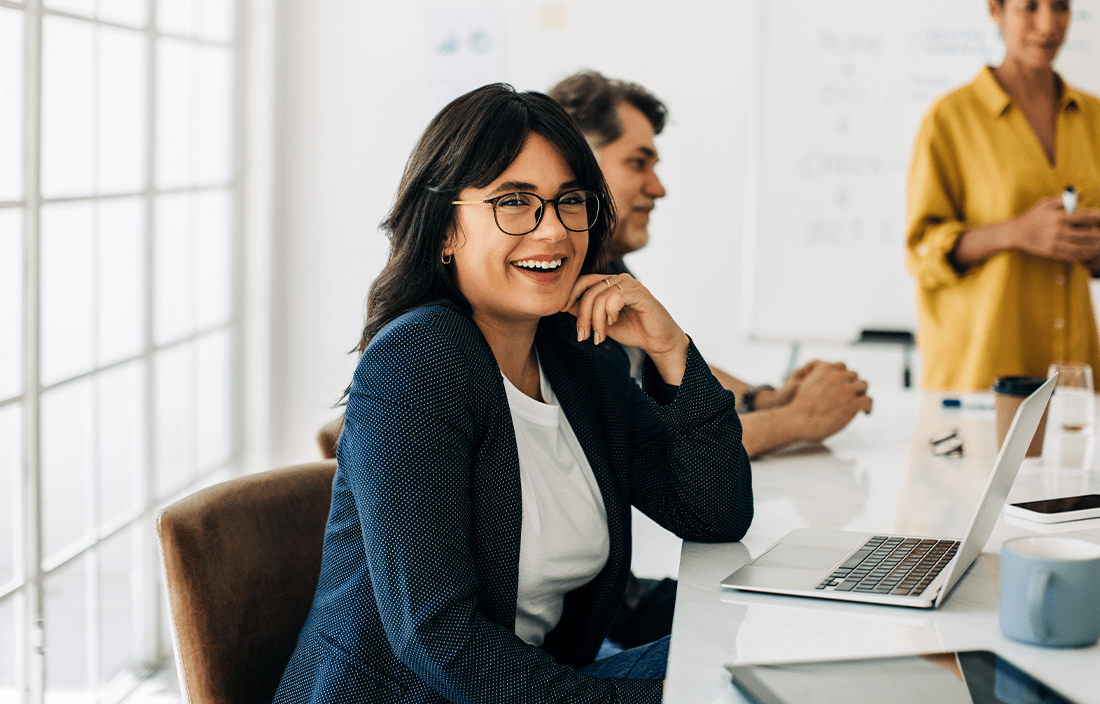 Nonprofit professional smiling at their desk.