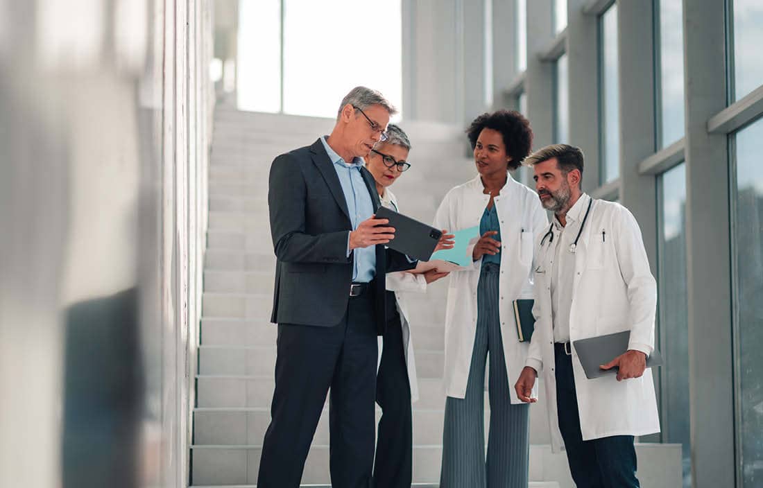 Doctors reviewing medical information in a hallway.