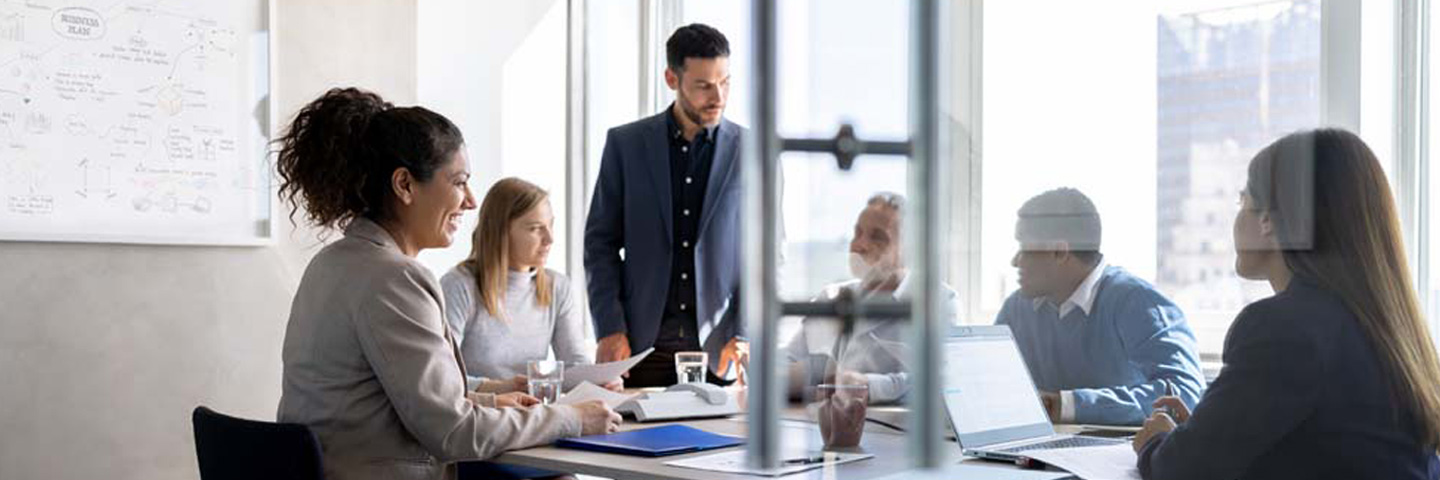 Public sector professionals having a roundtable discussion about the ERP lifecycle using a whiteboard.