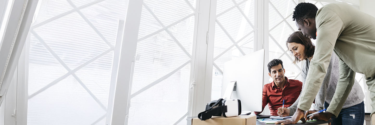 Government workers gathered around a computer at work.