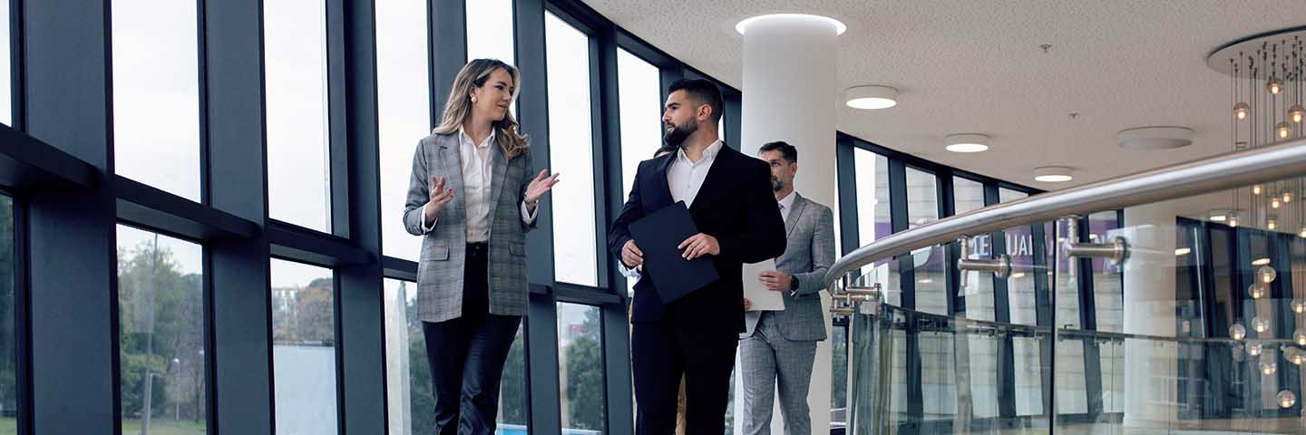 Business professionals walking down a hallway.