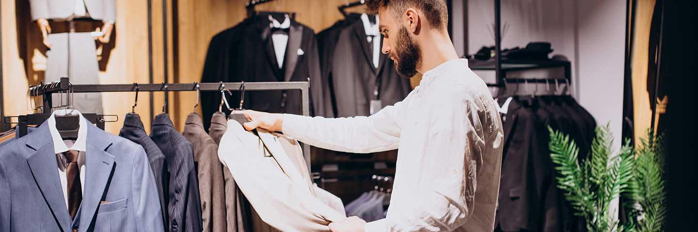 Shopper looking at a suit jacket in a retail store.
