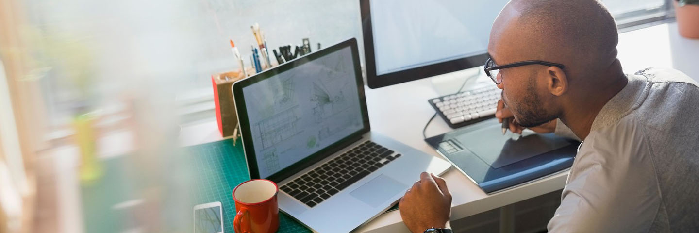 Business professional reading on their laptop.