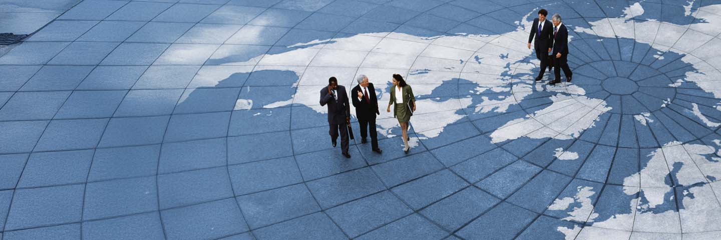 International business professionals walking across the world map.