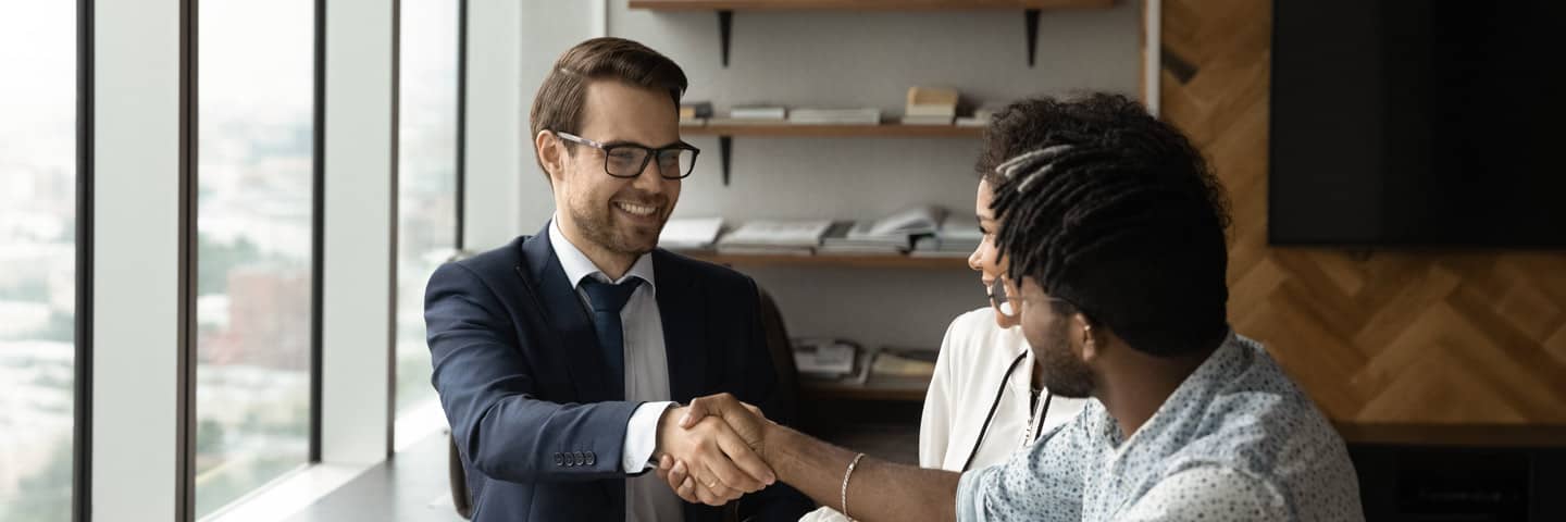 Financial advisor shaking hands with their clients.
