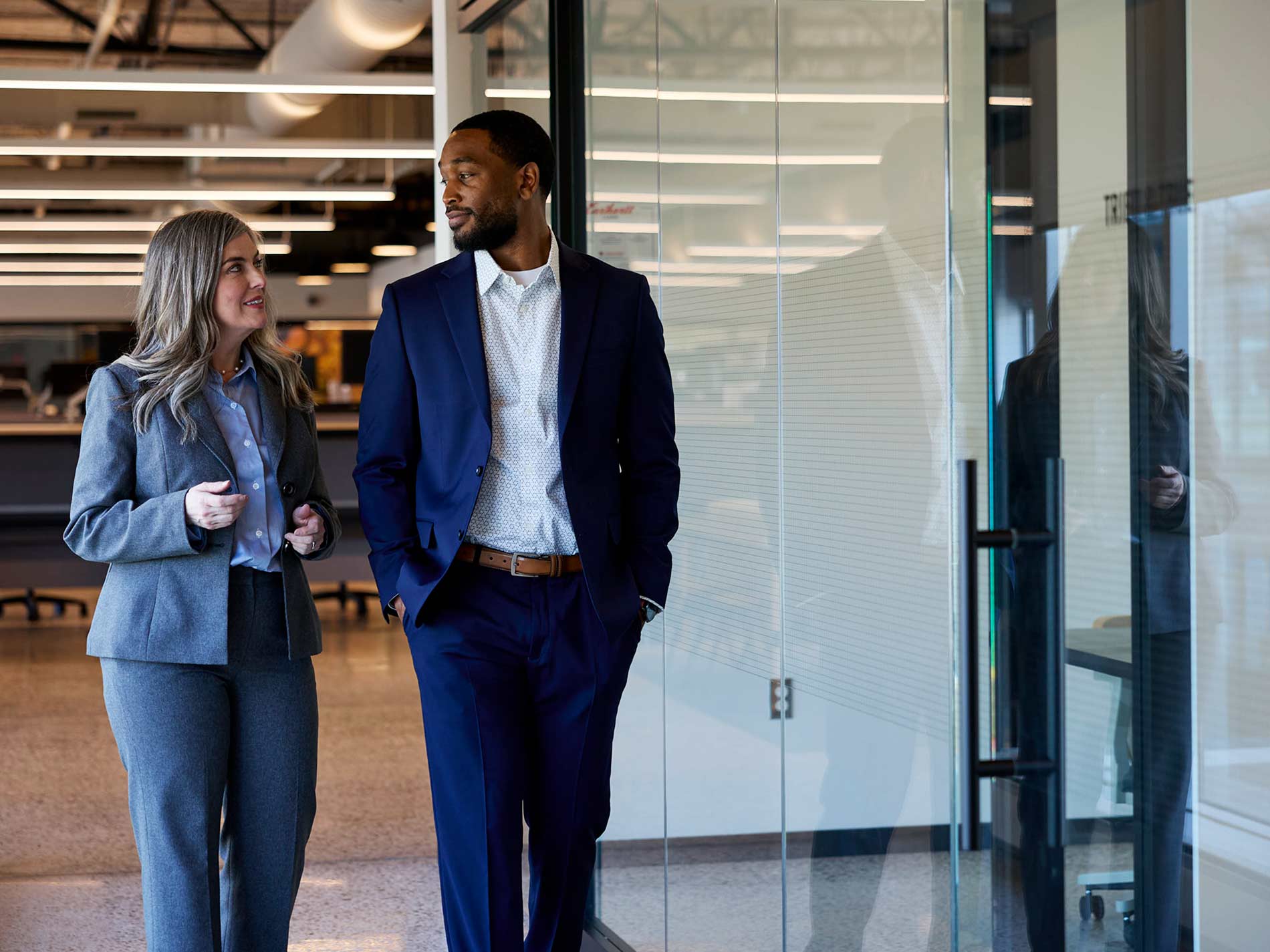 Two business professionals walking down a hallway.