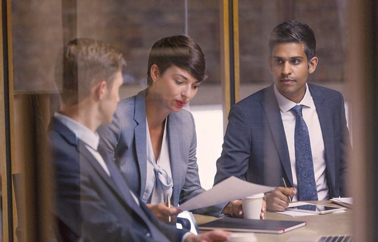 Business people looking over paperwork at a conference table.