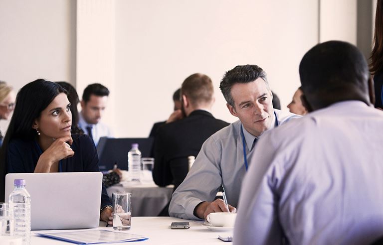 Business people sitting at a table talking.