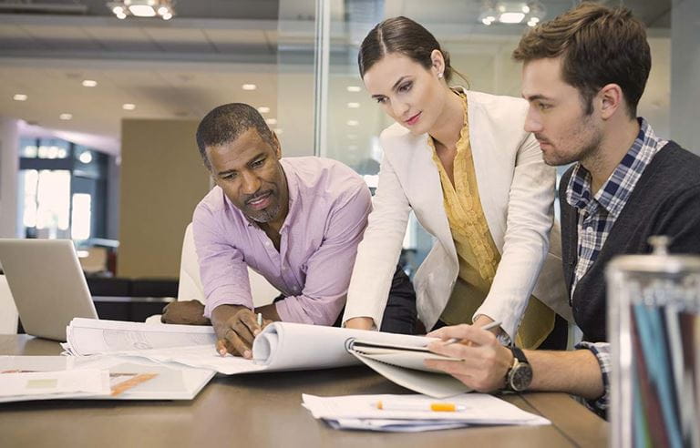 Photo of businesspeople reviewing documents together.