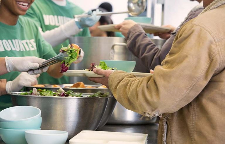 Image of volunteers serving food at a soup kitchen.