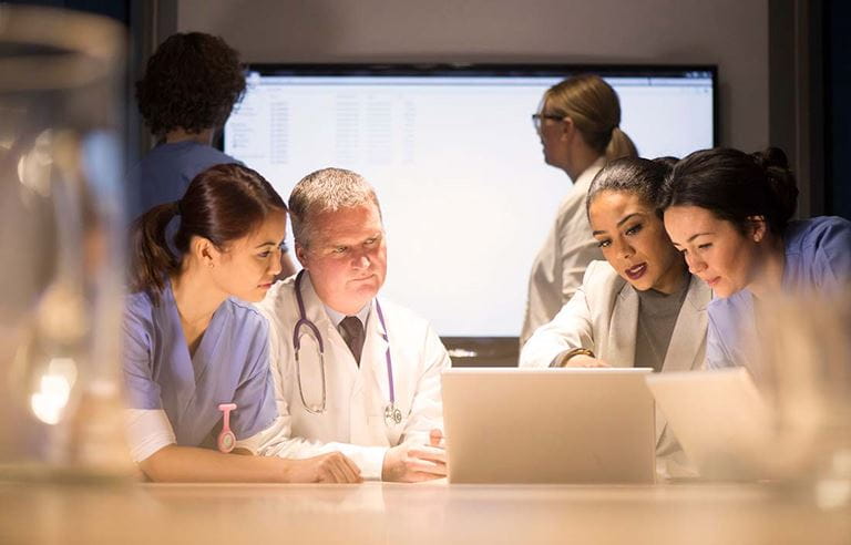 Photo of hospital staff discussing electronic health records. 