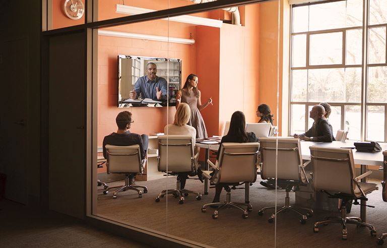 Image of people sitting in meeting room during video conference. 