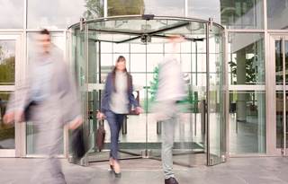 Image of people walking out of revolving doors