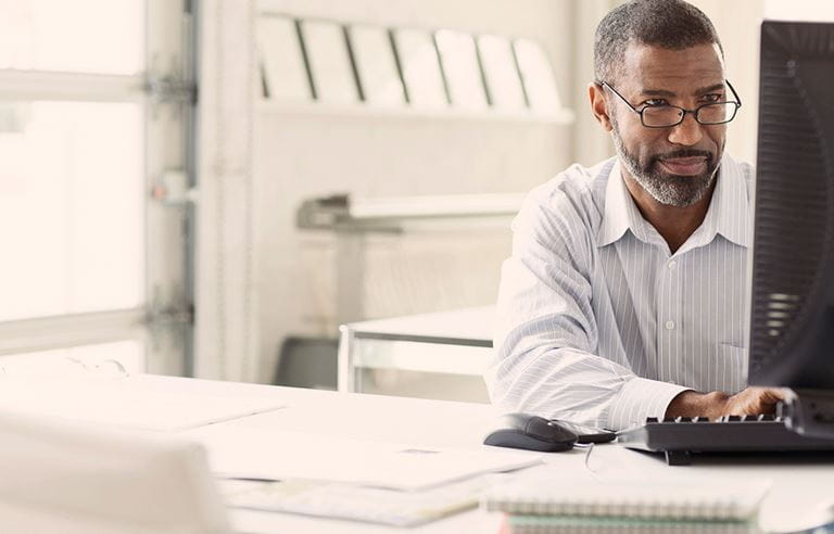 Image of a businessman working on his computer in an office.