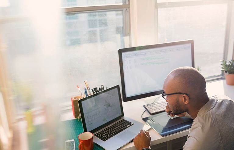 Man reviewing documents on computer for cybersecurity threats