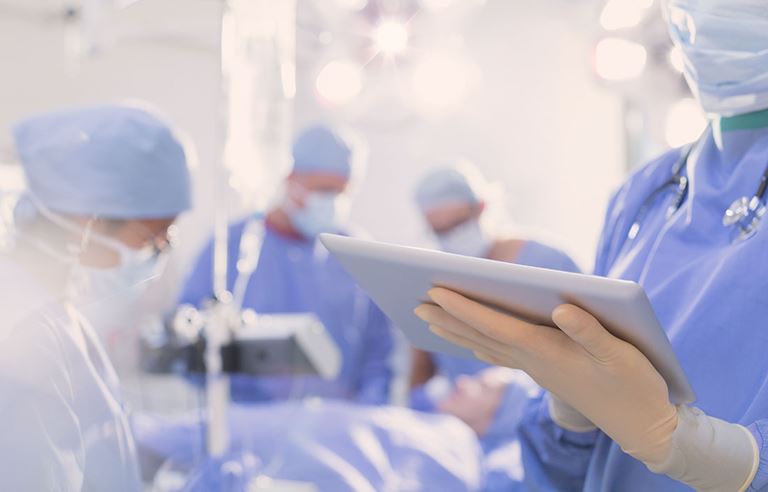 doctor holding Ipad in surgical room