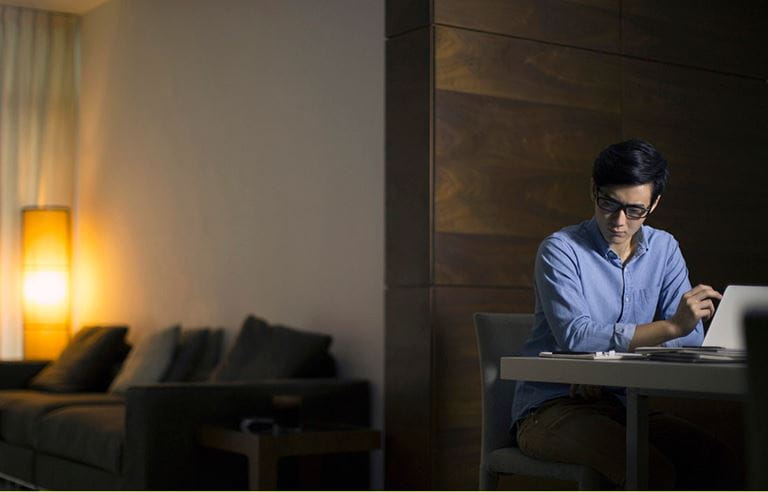 Man sitting in a darken room, reading papers