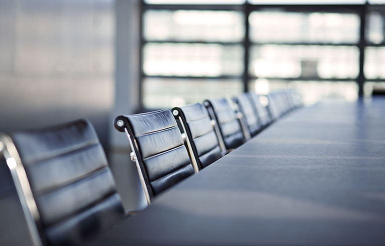 Conference room with a close-up shot of empty executive chairs.