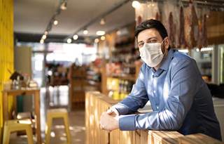 Photo of a small business deli owner in his shop.