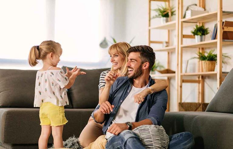 Husband and wife playing with their daughter at home