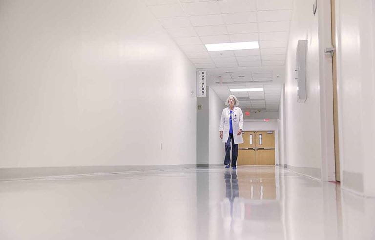 Healthcare worker walking down a hospital hallway