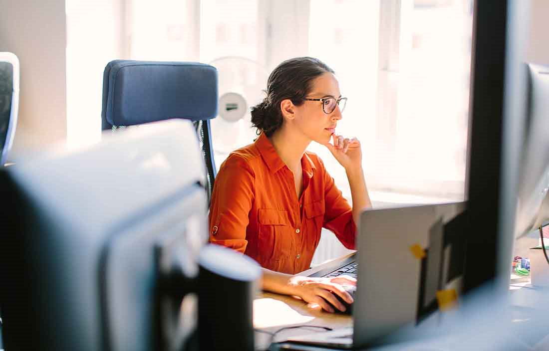 Business lady sitting at her computer desk looking at her monitor.