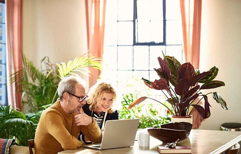 Man and woman sitting at a table on a laptop