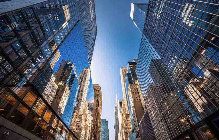 View of skyscraper buildings in a city looking up.