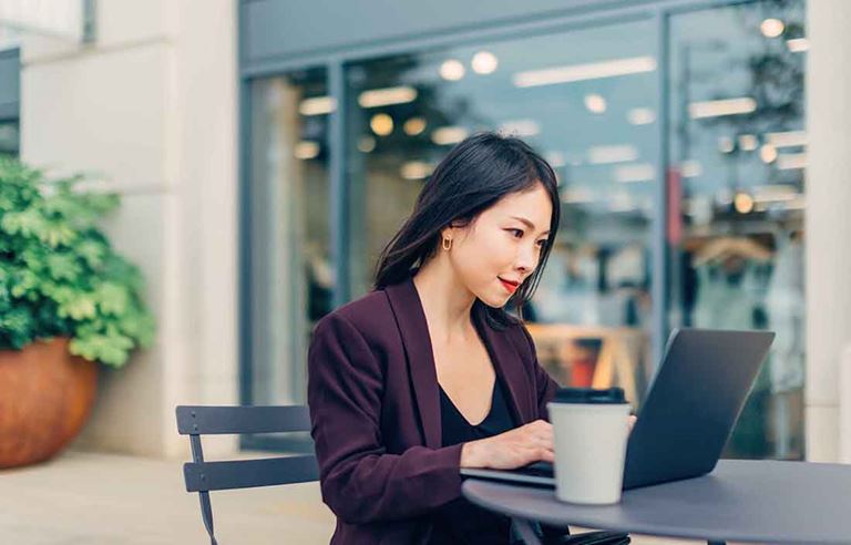 Woman sitting outside on a laptop