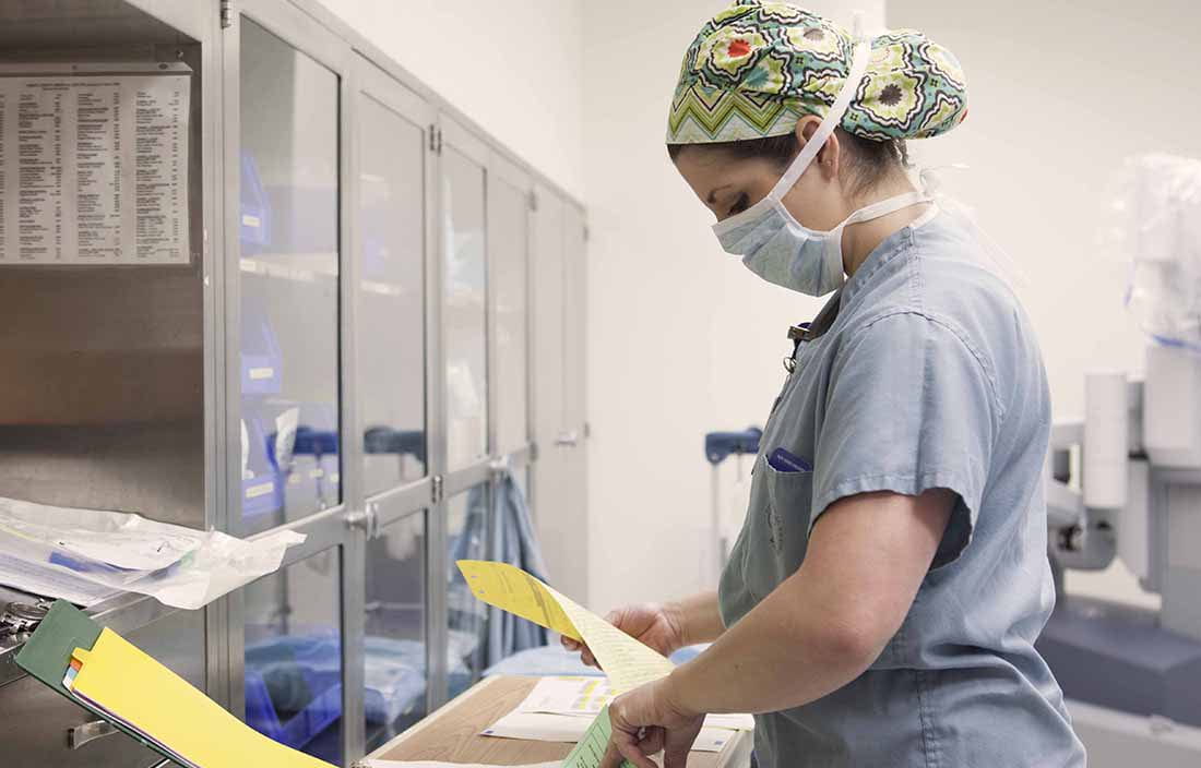 Doctor wearing facemasks reviewing paperwork.