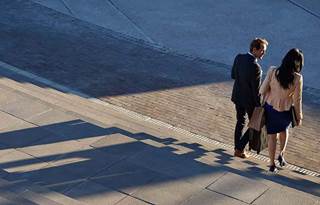 Two business professionals walking down a set of steps together.