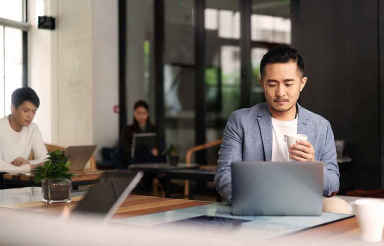 Businessman in a cafe area using a laptop computer.